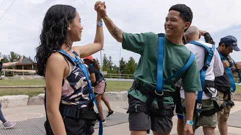 a man and woman wearing harnesses and holding hands