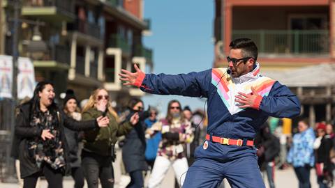 A man dancing, with people in the background following his moves