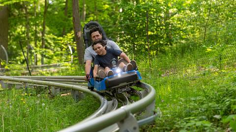 A father and son riding the Ridge Runner Mountain Coaster at Blue Mountain Resort