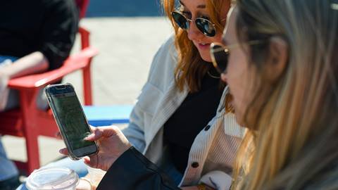 Two women looking at the Blue Mountain map on their cellphone