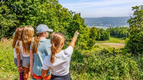 A group of girls excitedly pointing to the distance during a hike