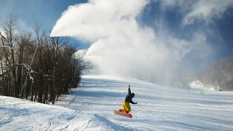 A person is snowboarding down a snowy slope.