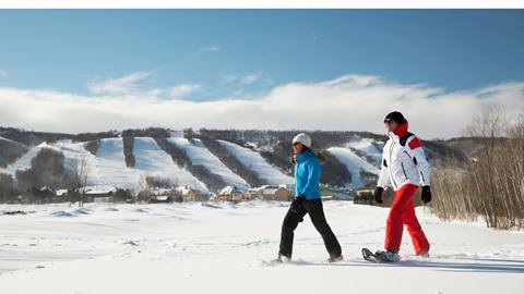 Two people snowshoeing in the snow.