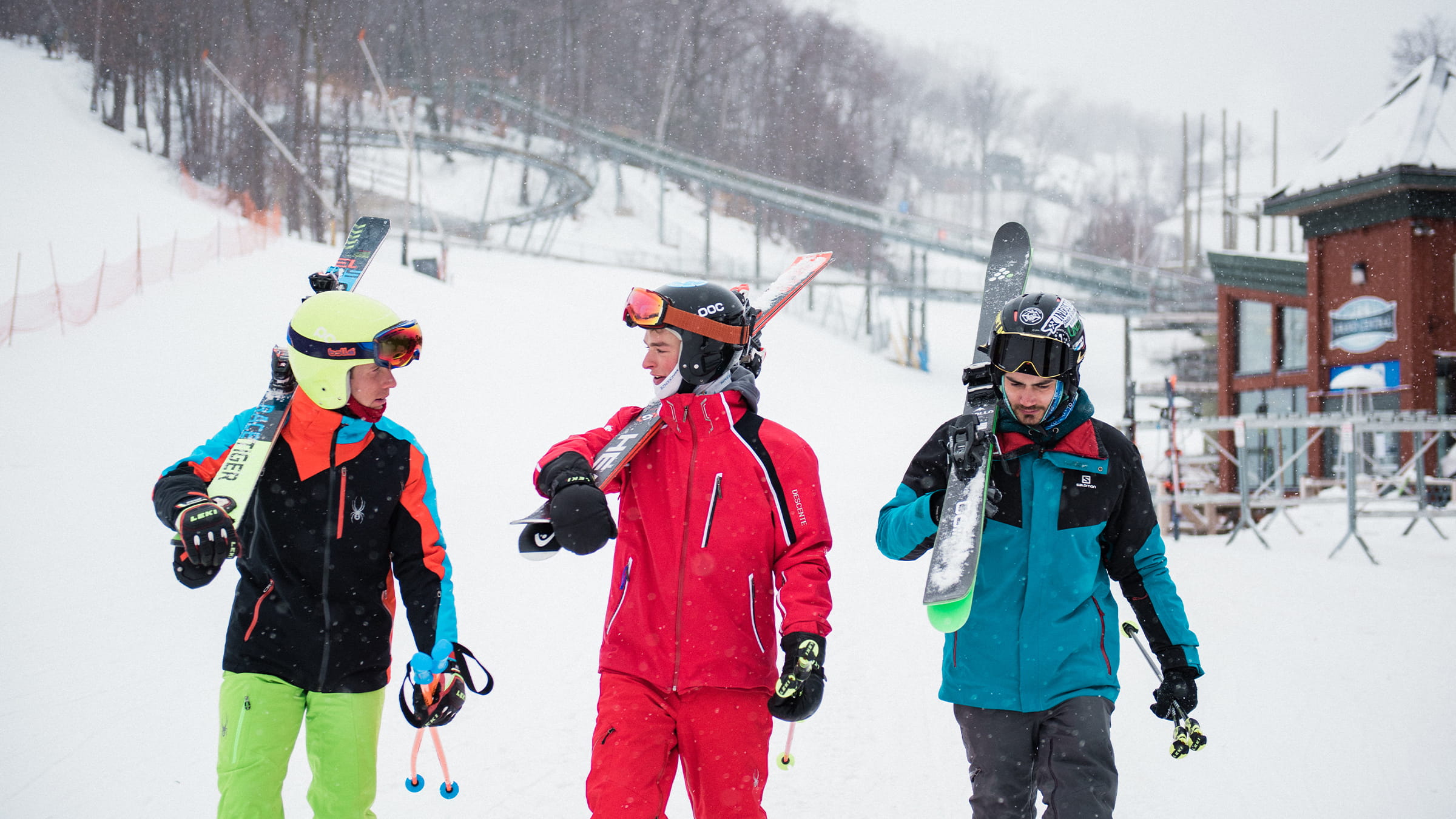 three boys walking to the lift with their skis