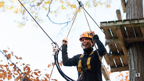 A woman on a zip line in the fall.