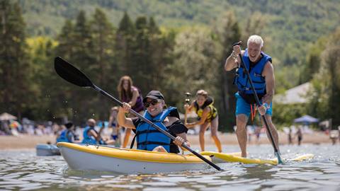 A women in a kayak and a man on a paddle board at the Blue Mountain Resort Private Beach