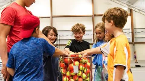 Group of Kids reaching into a basket of tennis ball at Blue Mountain Resort