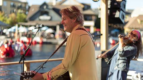 A man playing the guitar at Blue Mountain