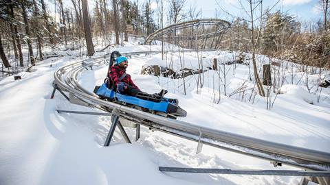 A person riding a roller coaster in the snow.
