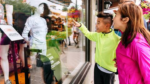 a boy and a women pointing at a store window