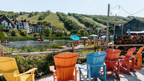 A row of chairs overlooking the mill pond under a clear blue sky at Blue Mountain Resort