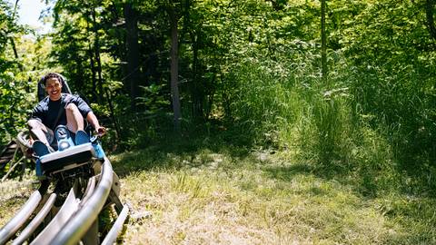 a man enjoying his ride down the Ridge Runner Mountain Coaster