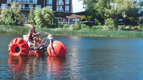 a mother and child enjoying a summer ride on a red water trike at the blue mountain mill pond