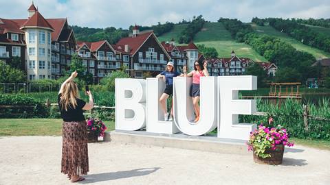 a group posing for a picture in front of the Blue Mountain Sign