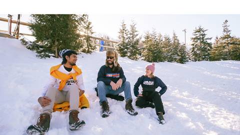 Three people sitting on snow 