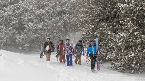 A group of people walking through the snow.