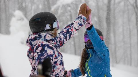 Two Friends giving high fives on hill at blue mountain