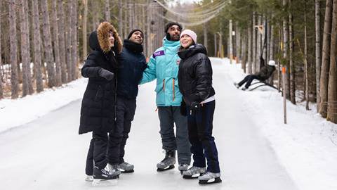 A group of people on ice skates in a wooded area.