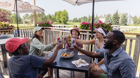 A group of people toasting at an outdoor table.