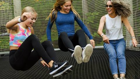 Three girls jumping on a trampoline.