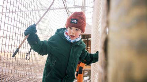 A boy in canopy climb in the winter