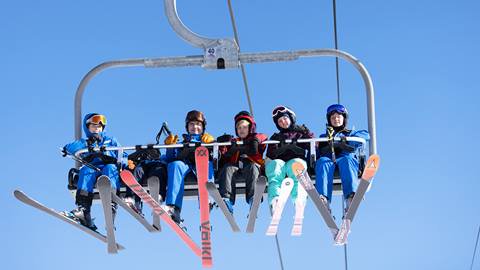 A group of people sitting on a ski lift.