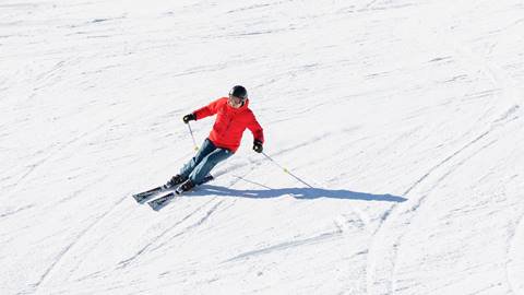 A person skiing down a snow covered slope.