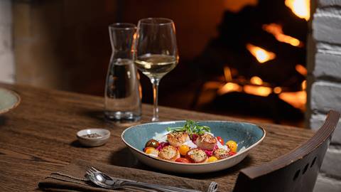 A bowl of food on a table next to a fireplace.