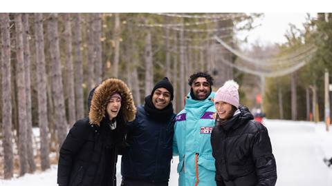 A group of people standing together in the snow.