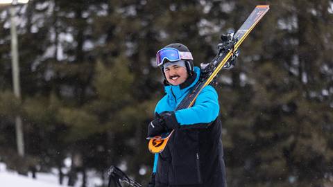 A man carrying his skis on his shoulders
