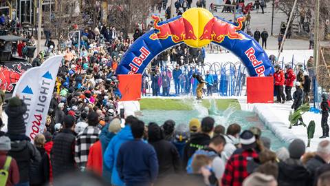 A crowd of people watching a man skiing.