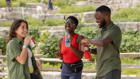 three happy people having something to drink