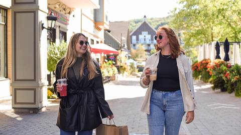 Two People walking with coffee in their hands at the Blue Mountain Resort