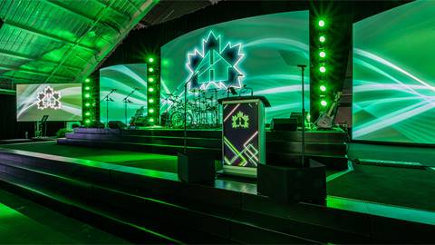 A stage with green lights and a green screen.
