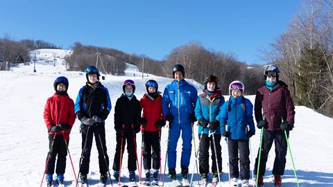 A group of people standing on skis in the snow, enjoying a winter day on the slopes at Blue Mountain Resort