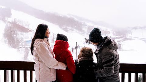 a family standing on the balcony at the Weider Lodge Village Suite