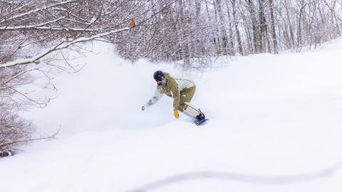 a snowboard riding through some powder