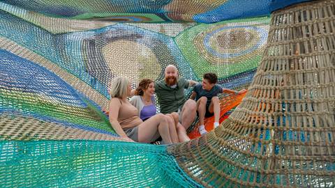 a family enjoying the Cocoon Crawl Playscape