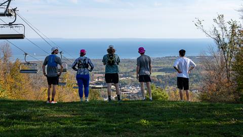 a group of people standing on a hill overlooking a body of water