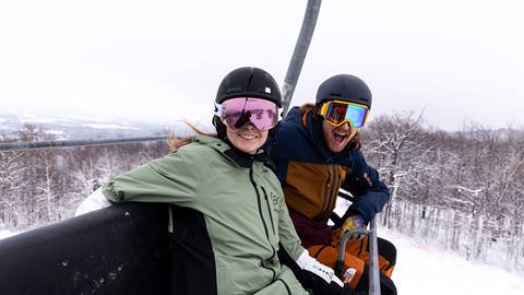 Two people on a ski lift.