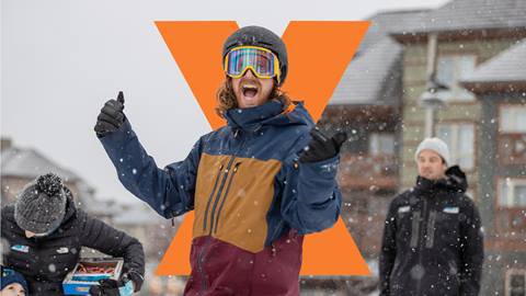 A man in ski gear celebrates enthusiastically on a snowy day