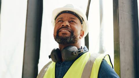 A construction worker wearing a hard hat and headphones.