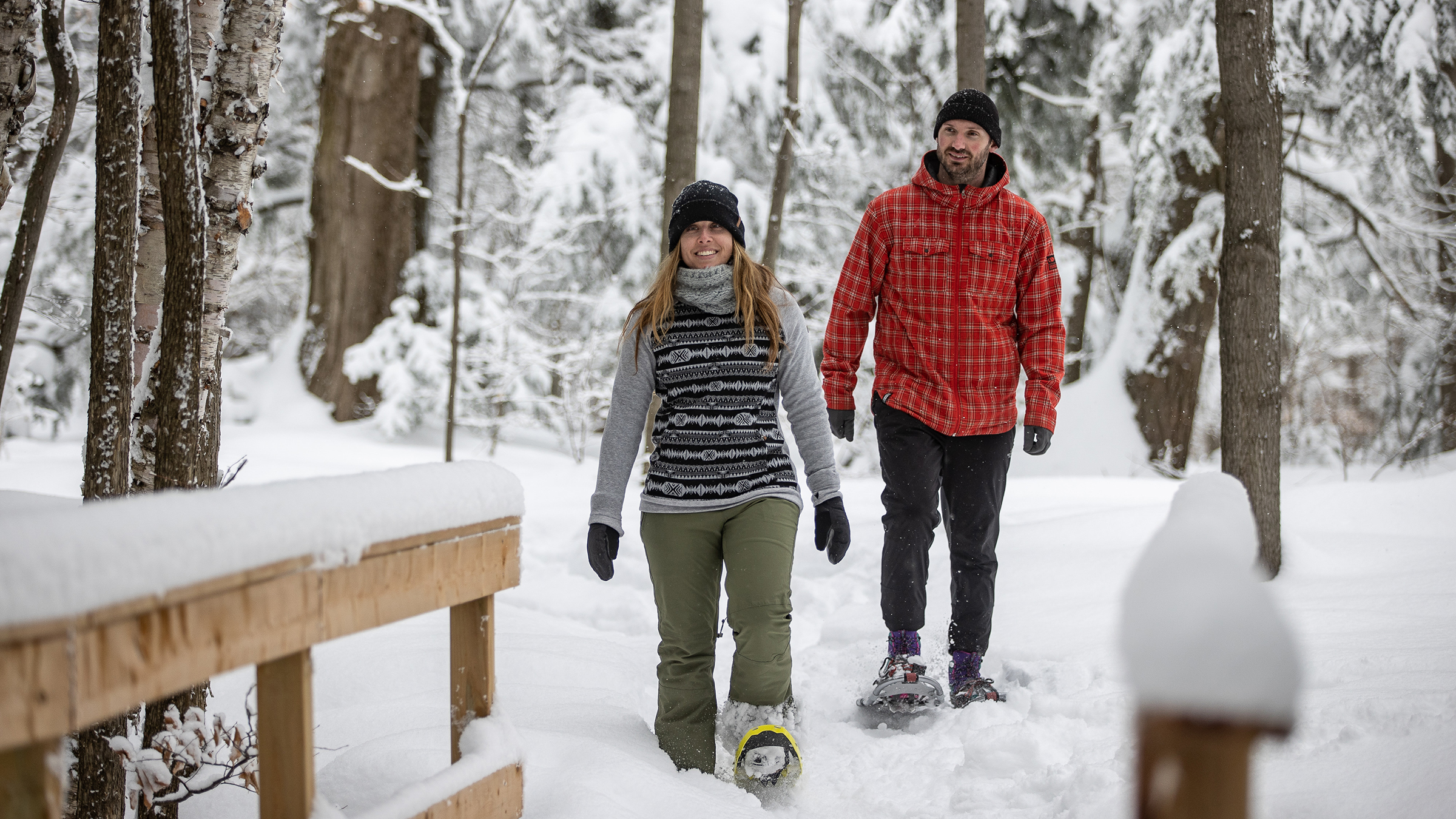 Pair of people hiking through the trails on snowshoes at Blue Mountain