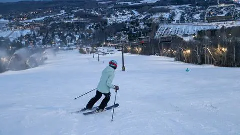 Person skiing down Blue Mountain during night Skiing with their 5x7® Pass