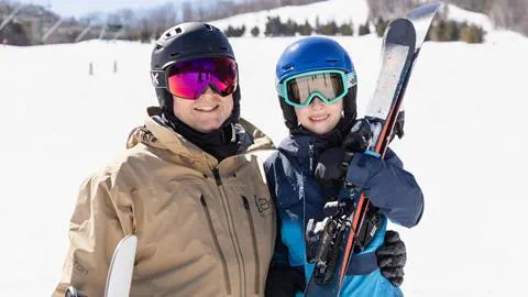 Pair of people on Blue Mountain Resort smiling with their ski gear
