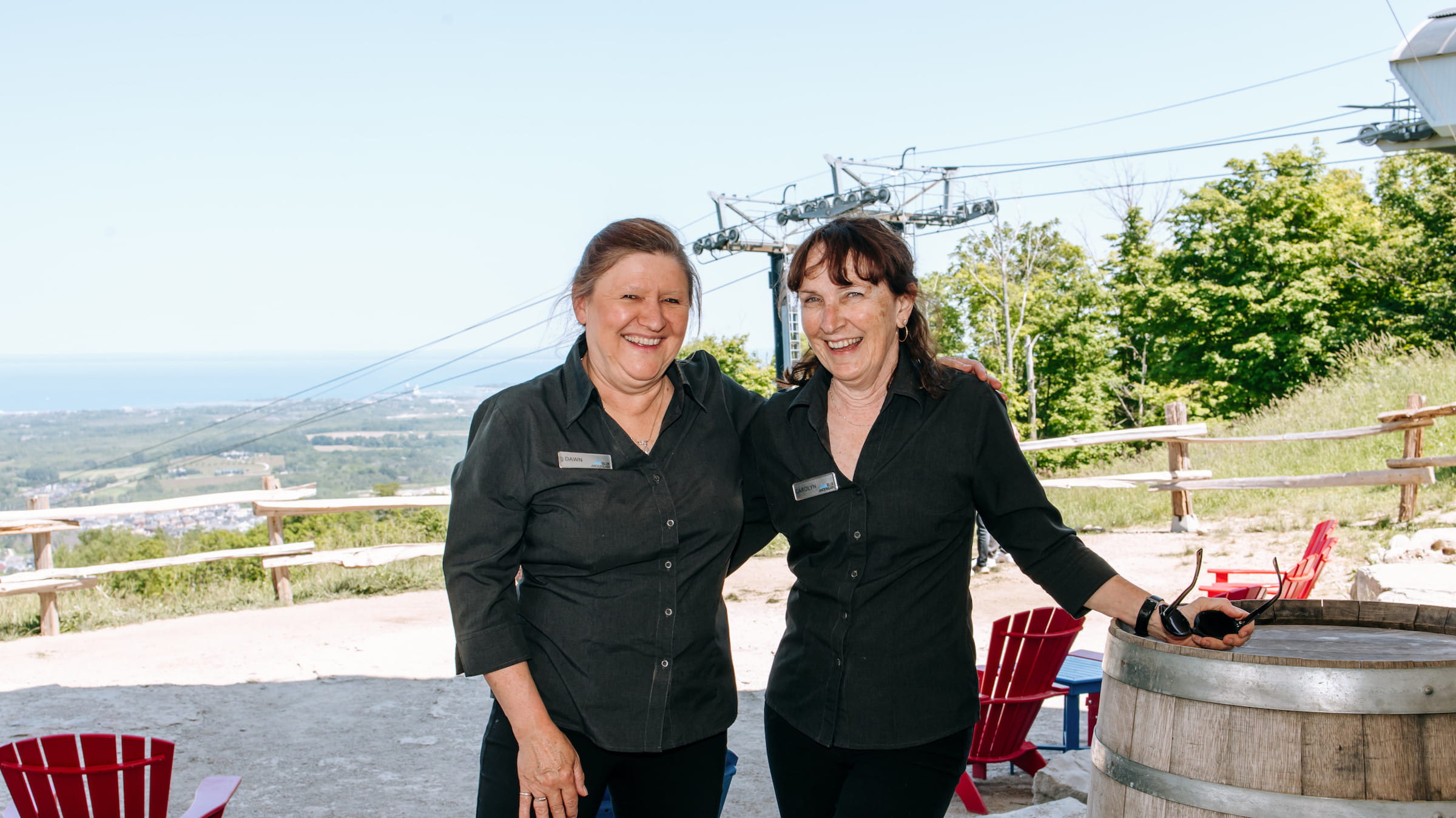 Two employees standing in Summitview Restaurant at Blue mountain overlooking Georgian Bay