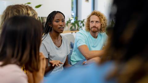 A group of people sitting around a table talking.