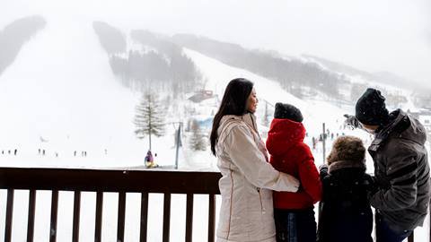 A family standing on the balcony of their room in the Village Suites