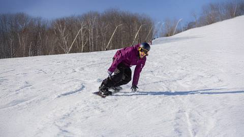 a smiling man snowboarding at Blue Mountain Resort