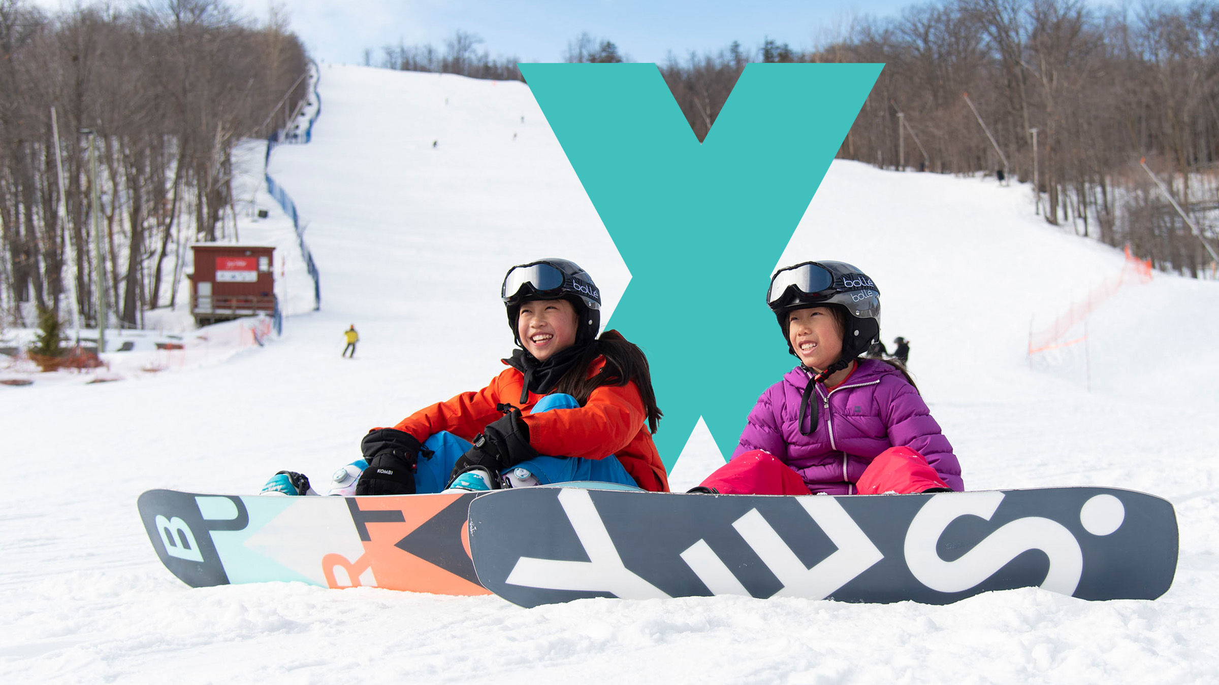 Two snowboarders sitting at base of Blue Mountain